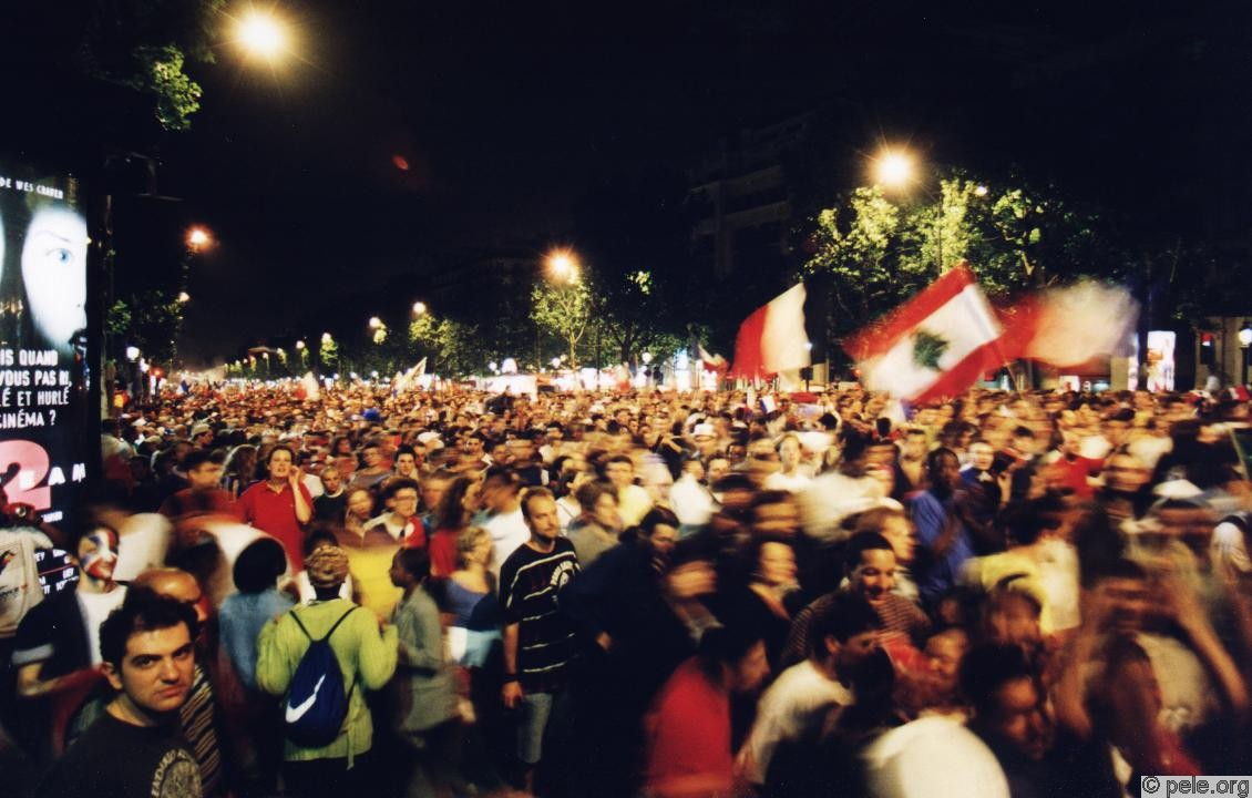 Drapeau Liban parmi foule en mouvement sur les champs Elysées le soir du 12 juillet 1998